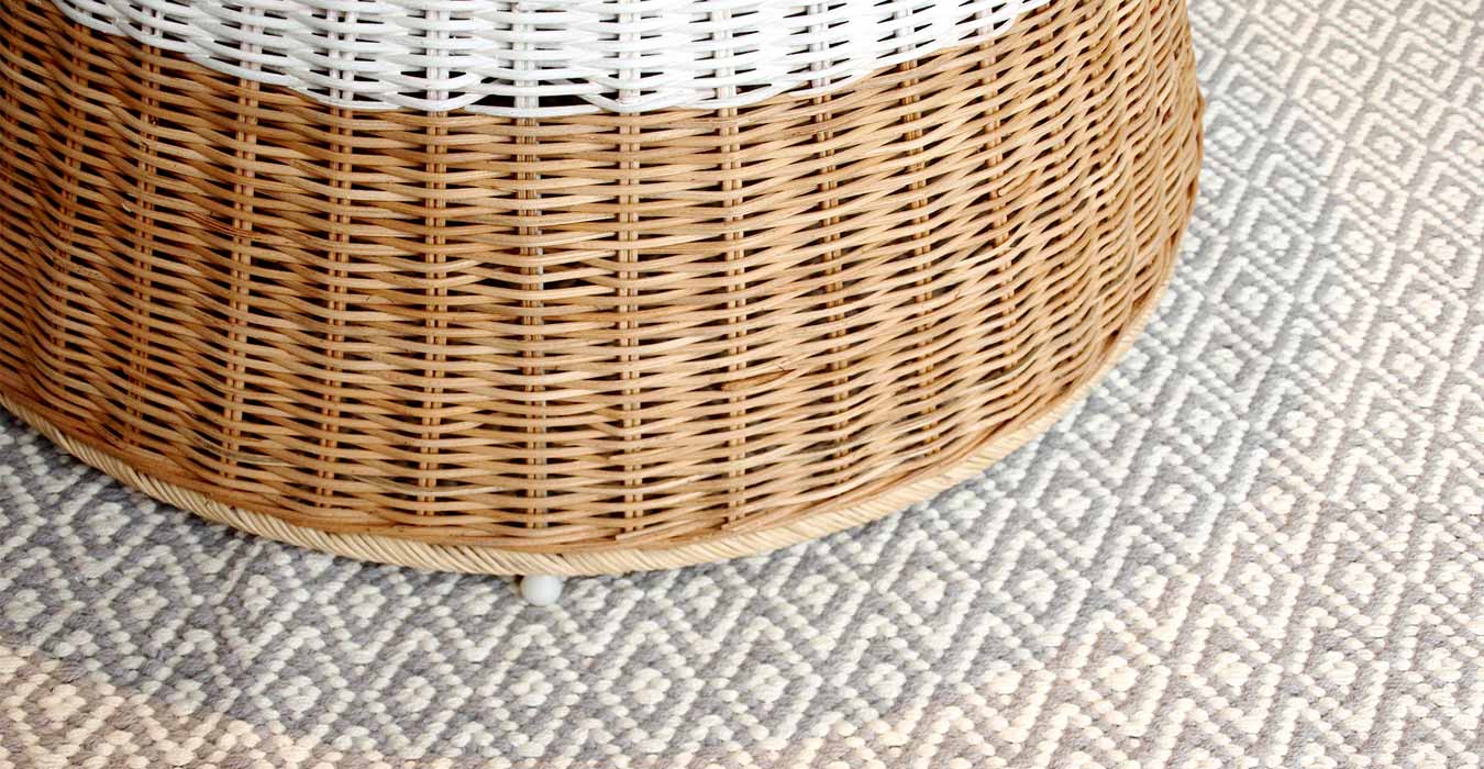 Wicker table on top of a cotton grey carpet